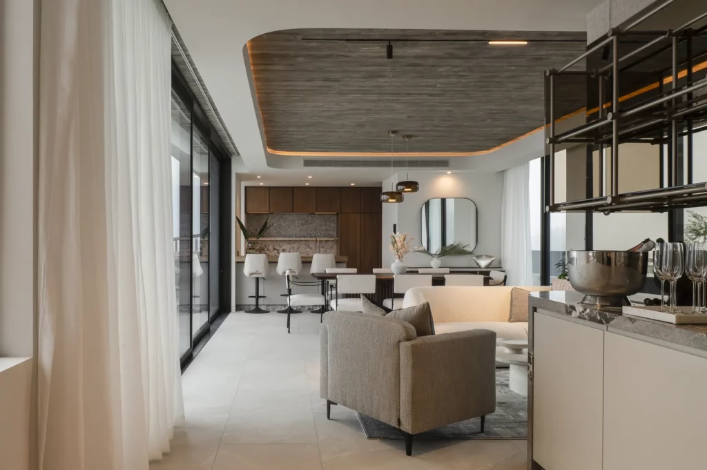 Open-plan kitchen and lounge with marble island, curved sofa and striped accent chair
